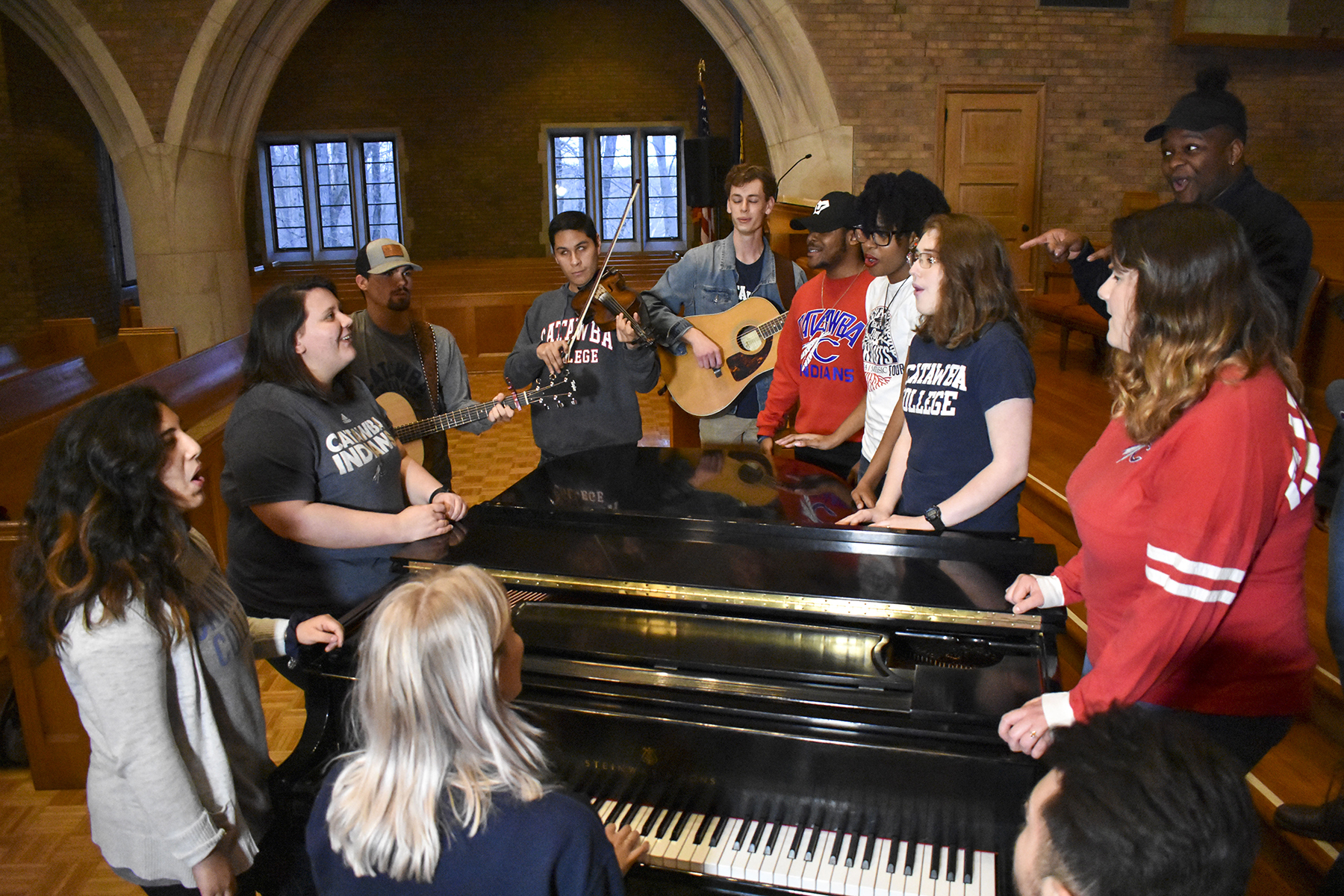 Worship Arts Singers around piano